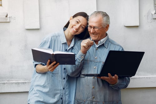 mujer-ensenando-su-abuelo-usar-computadora-portatil