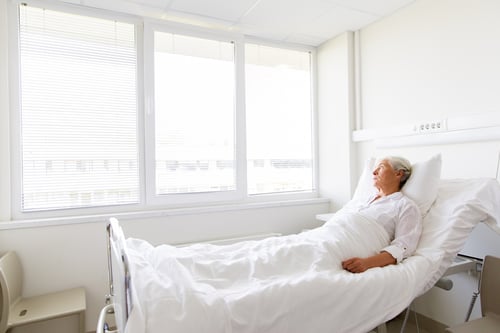 sad-senior-woman-lying-bed-hospital-ward