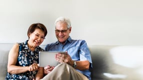 senior-couple-using-digital-device-in-living-room (1)