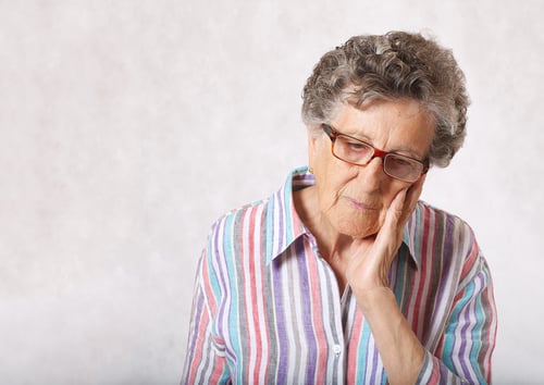 senior-woman-70-80-years-old-suffers-from-toothache-gray-background